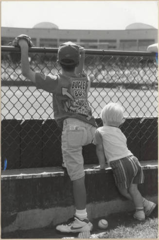 Photo of Two Children in Grassy Spectator Area at Tempe Diablo Stadium.
