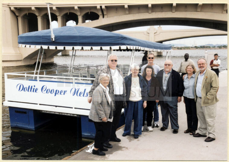 Photo of a group next to the Dottie Cooper Nelson Boat by Mill Ave. Bridge.