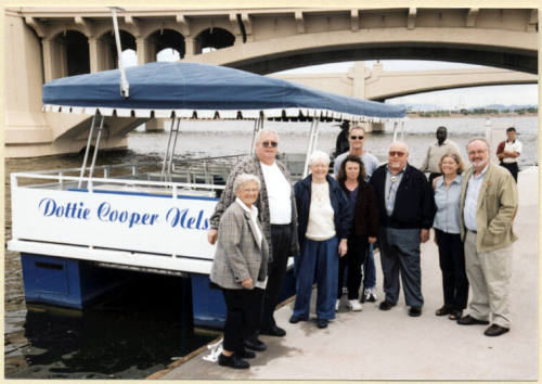 Photo of a group next to the Dottie Cooper Nelson Boat by Mill Ave. Bridge.