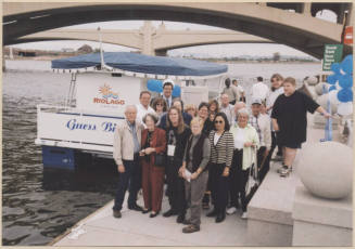 Photo of group of people posing by the Guess Birchett Boat on Tempe Town Lake.