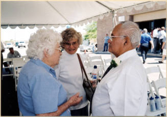Color photograph shows group standing under reception tent at dedication of Johnny Martinez Water Dept. Treatment Plant.