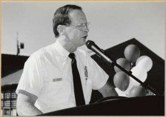 Black and white photograph of Fire Chief Cliff Jones speaking at dedication of Apache Blvd. Fire Station