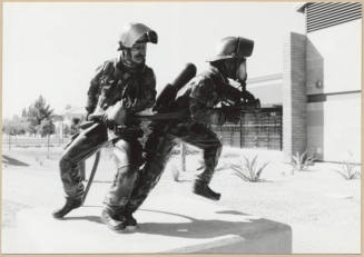 Black and white photograph of statues of fire fighters at the dedication of Apache Blvd. Fire Station