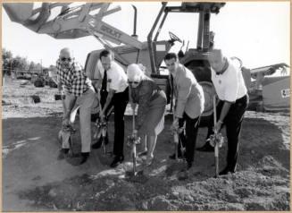 Black and white photograph of mayor and council members at fire station ground digging