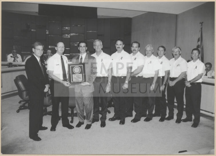 Fire Chief Cliff Jones, Neil Giuliano, Jim Gainter, and members of the fire department receiving accreditation