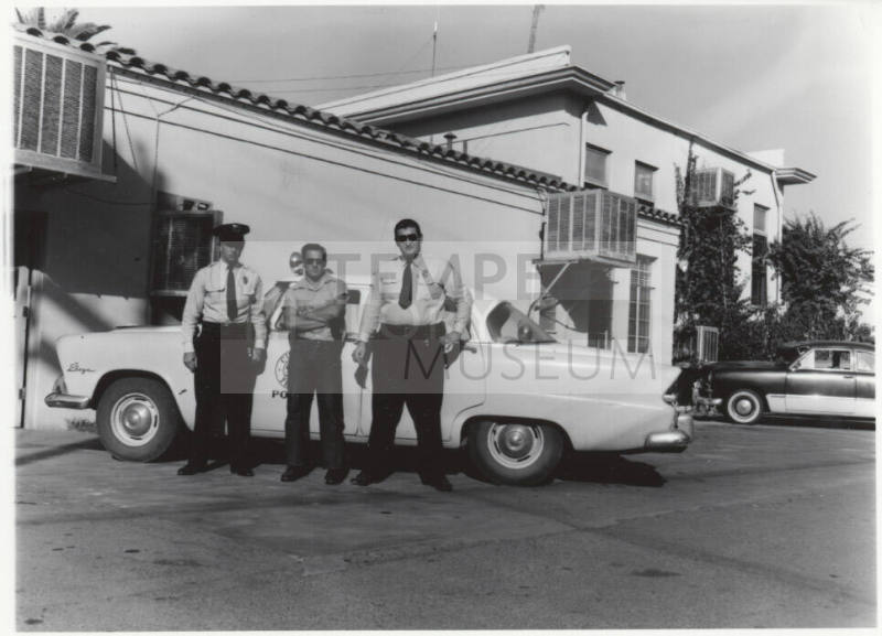 Two police officers and another man behind the Tempe Police station