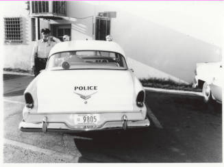 Police car and officer behind the Tempe police station