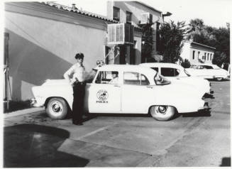 Police car and officers behind the Tempe police station