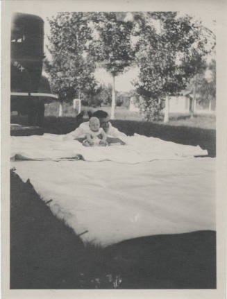 Adult and Child on Blanket Behind Car