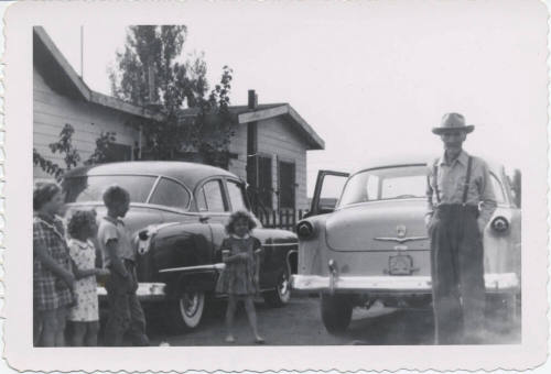 Four Children and a Man Behind Two Cars