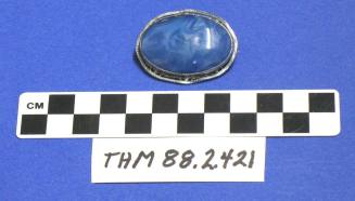 Oval, silver brooch with blue cabochon