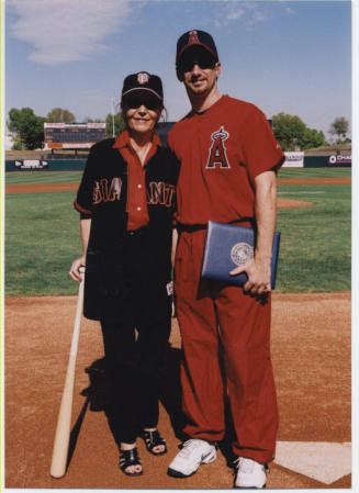 Photo of Mayor Giuliano in a Baseball Uniform with someone in Giant Fan clothing.
