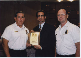 Photograph of Mayor Giuliano Presenting Gary Ells with Arizona Fire Service Hall of Fame Plaque, 2002