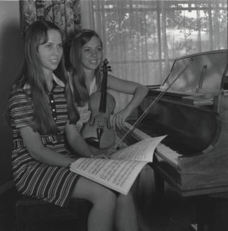 Two Teenage Girls Sitting at a Piano