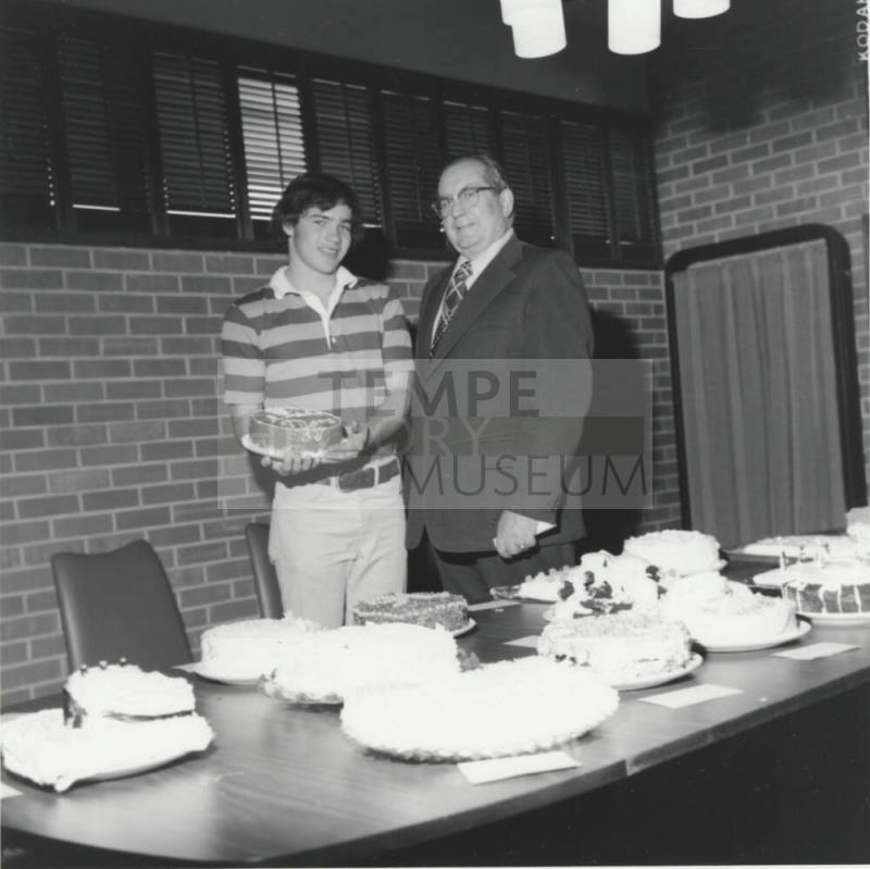 Student and Bill Boyle with cakes