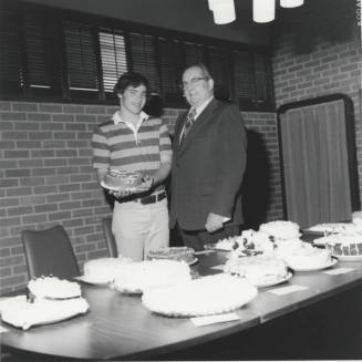 Student and Bill Boyle with cakes