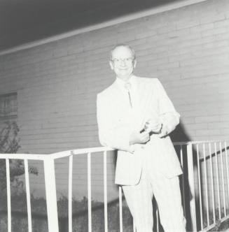 Bill Hanna Stands Outside Holding Watch