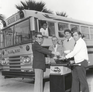 Men standing in front of a school bus