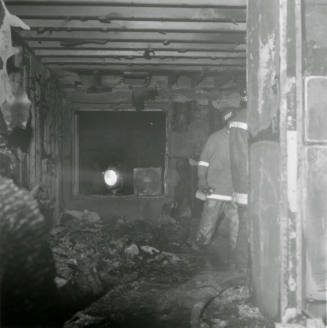 Firemen in burned-out structure, February 1978