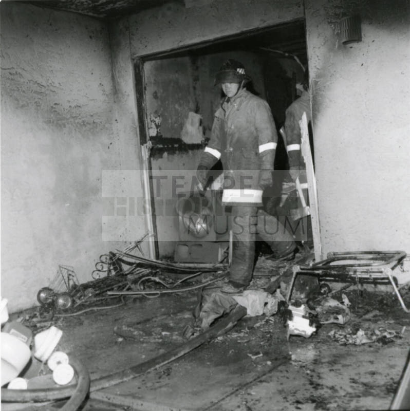 Firemen in a burned-out structure, February 1978