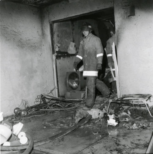 Firemen in a burned-out structure, February 1978