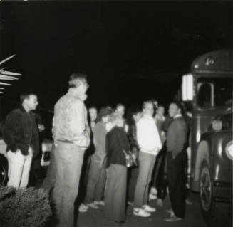 Unknown group of men standing beside a bus
