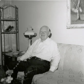 Unidentified happy and smiling man on sofa