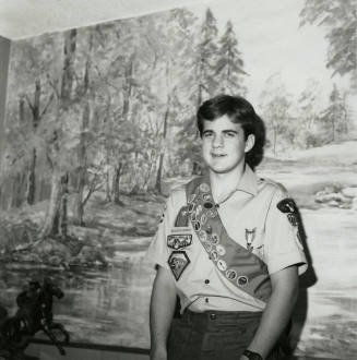 Boy Scout standing in front of a landscape mural