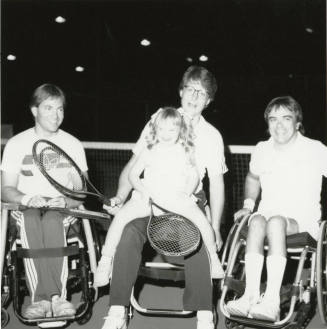 Unidentified Group of 3 wheel-chair-bound people, 1 holding tennis racquet & small girl with racquet
