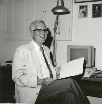 Unidentified man sitting at desk with computer - (1 of 2)