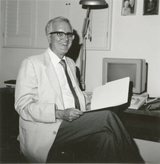 Unidentified man sitting at desk with computer - (2 of 2)