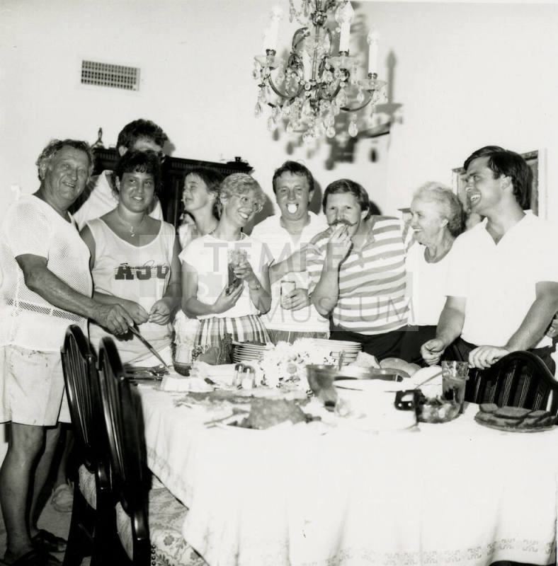 A group of people standing around a table at a party