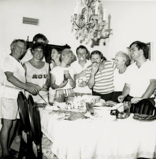 A group of people standing around a table at a party