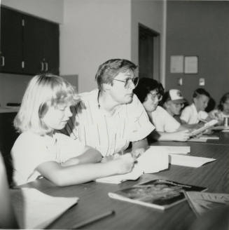 Unidentified group of adults and children sorting through paperwork (1of 2)