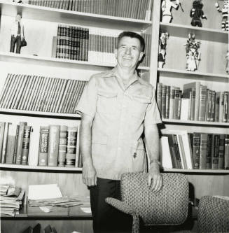 Unidentified man standing in front of medical books