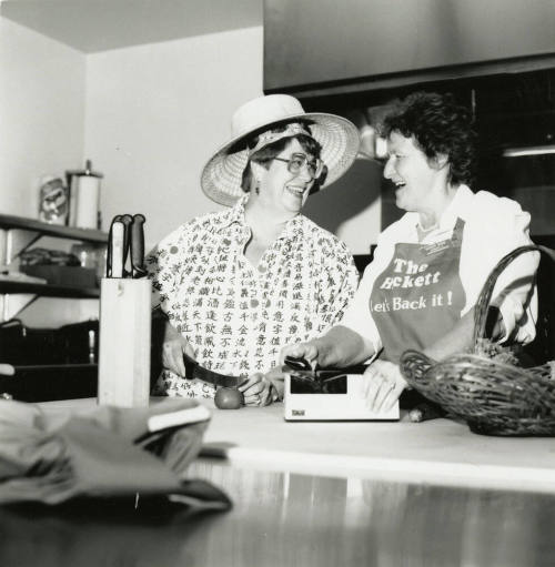Women in a kitchen, aprons "The Hackett - Let's Back It!"