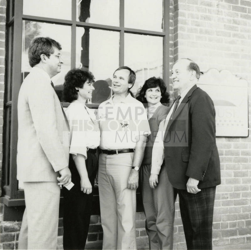 Three unidentified people, Harry Mitchell (center), and Richard Neuheisel (left) at the Hackett House