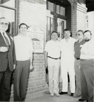 Five unidentified men and Richard (Dick) Neuheisel (third from right) at the entrance of the Hackett House