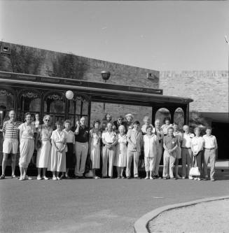 Large unidentified group outside a brick building