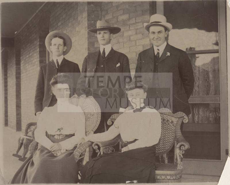Group of Three Men Standing, Two Women Seated