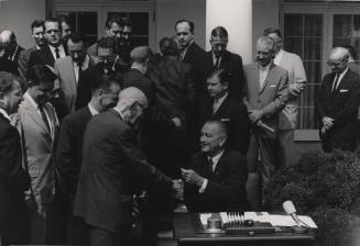 Carl Hayden and Lyndon Johnson shake hands.