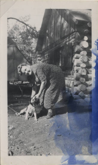 Sallie Hayden and a dog at a cabin
