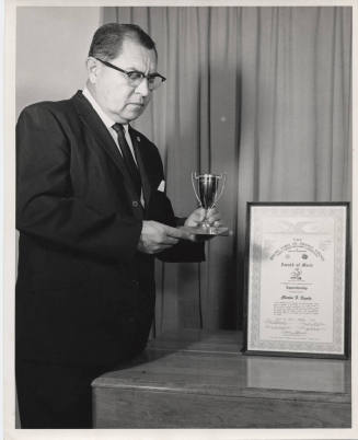 Charles Sigala Holding a Trophy, ca 1963