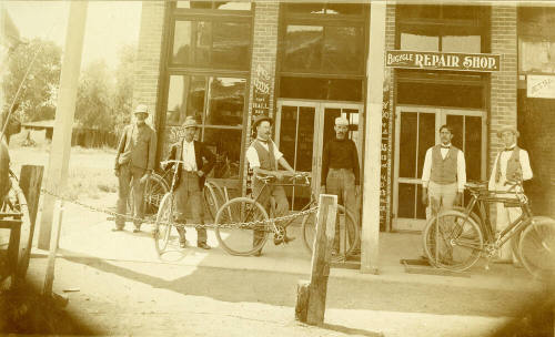 Chris Sigala and other men standing in front of Bicycle Repair Shop