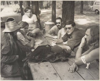 Photo of six people at picnic table in the woods
