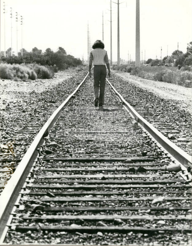 Person Walking Down Railroad Tracks