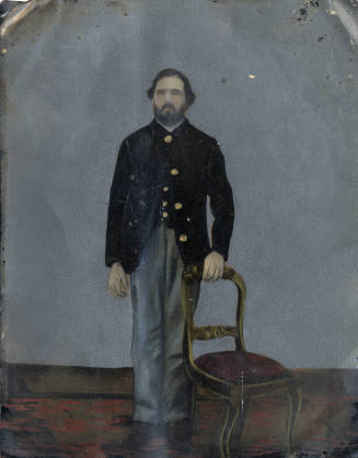Bearded Man in Civil War era Northern uniform standing with chair