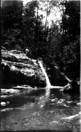 waterfall, with 2 figures standing on top