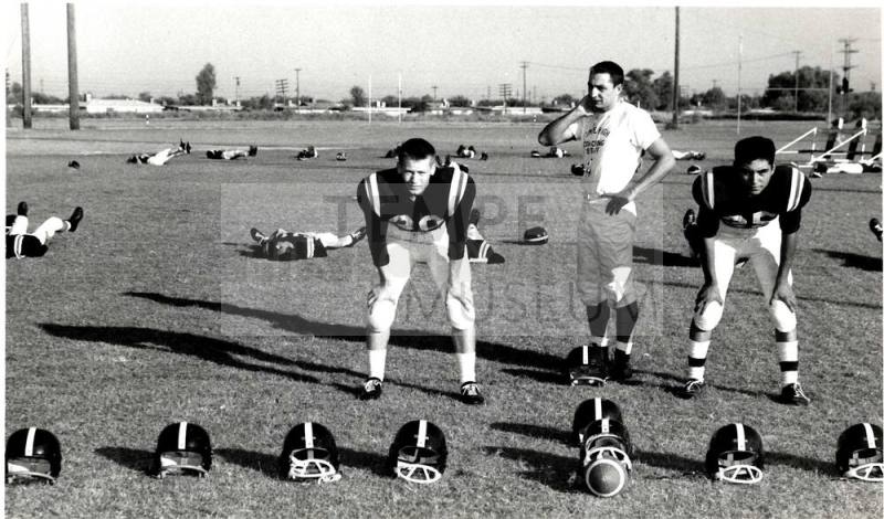 Photograph of Tempe Union Football Players Surrounded by Empty Helmets