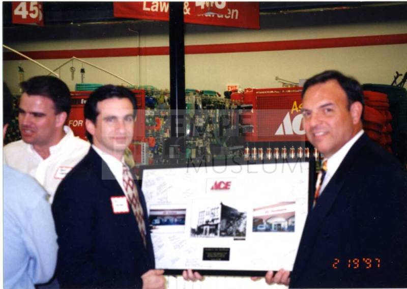 Photograph - 2 Men holding framed photos at the Grand Opening of Ace Hardware